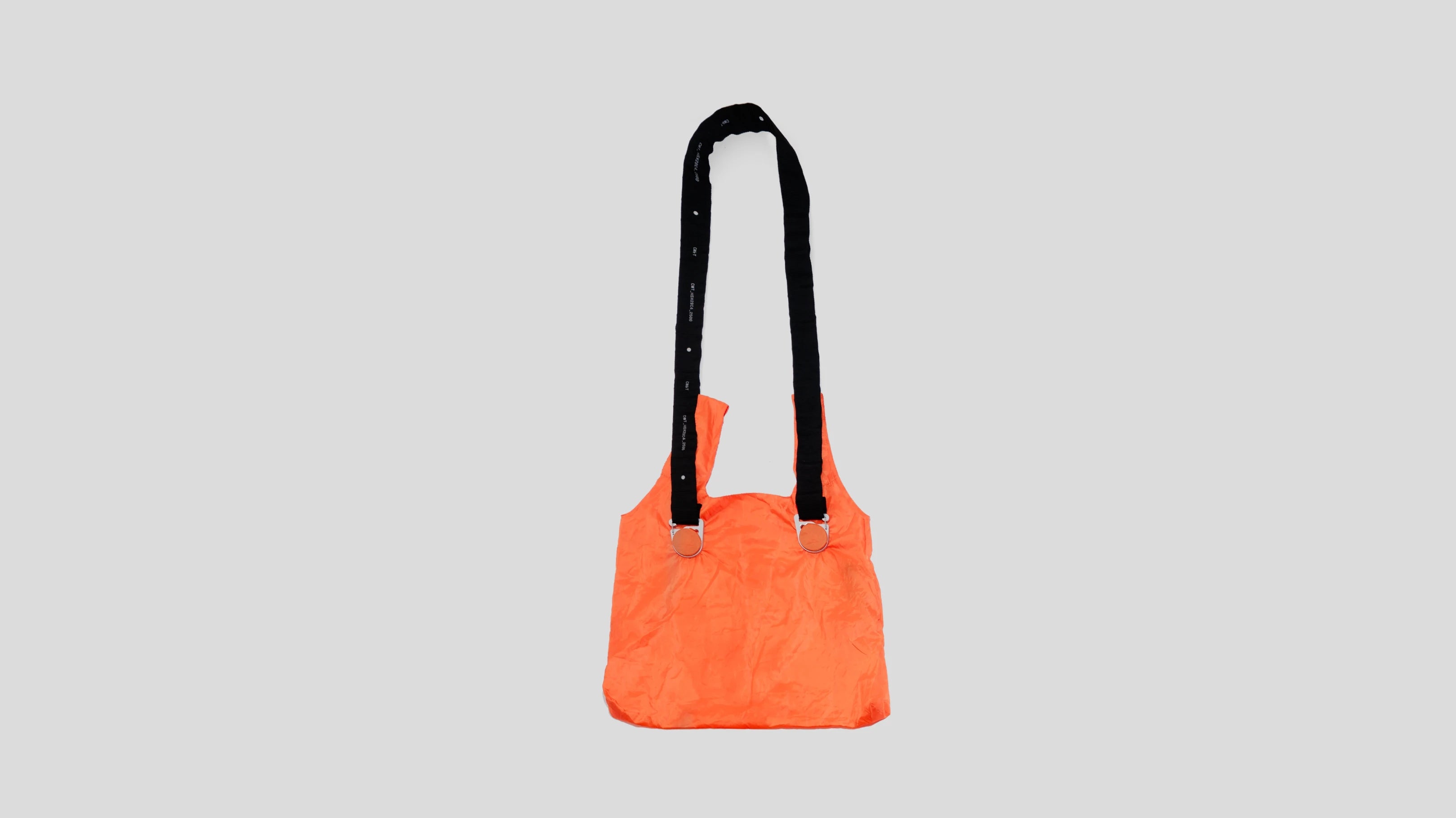 Orange bag with black handles on a light gray background